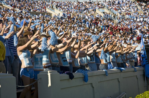 UNC students cheering together at a football game in a tar pit