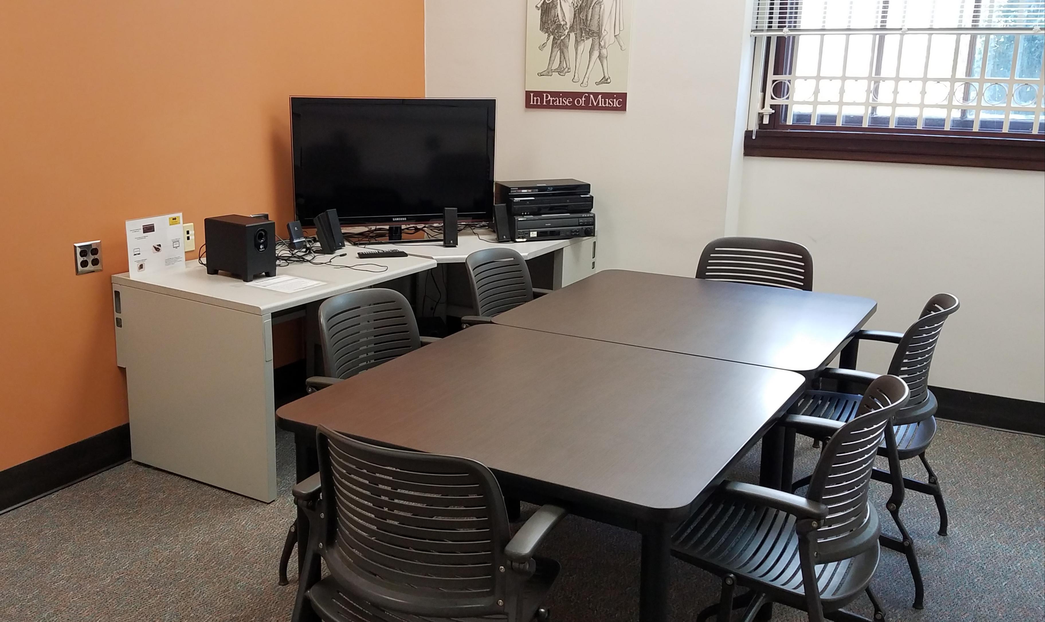 This room has a study table with six seats, and a separate desk with a large TV and AV equipment.