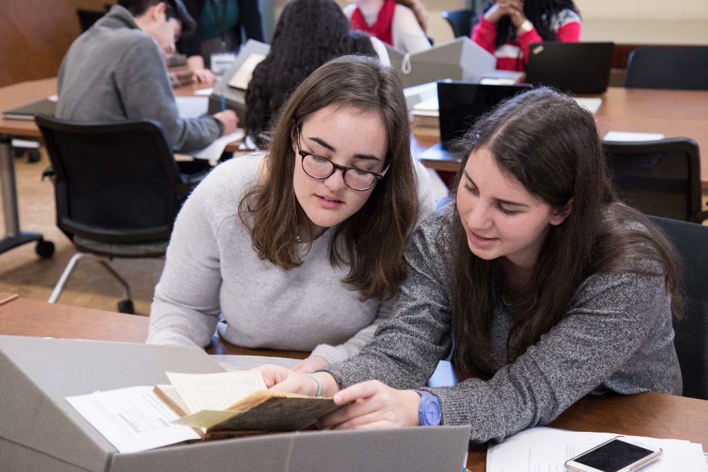 Two students examine archival materials.