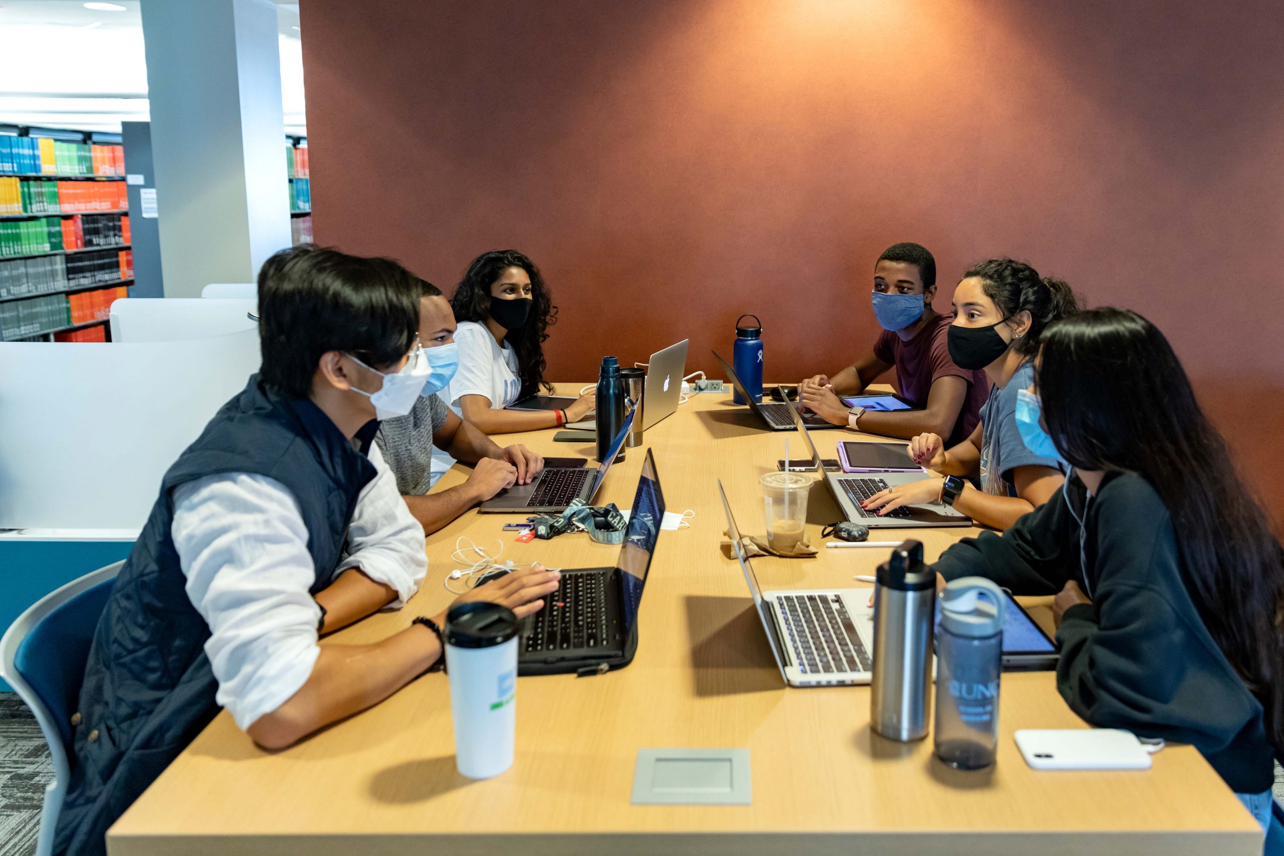 A group of students converse around a large table in the Health Sciences Library