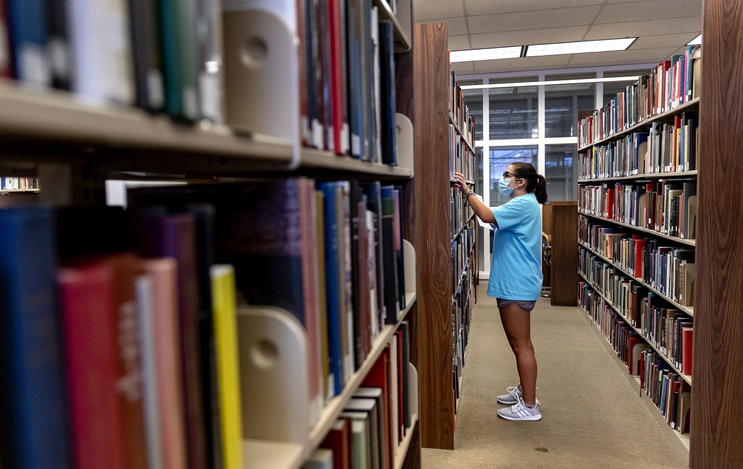 Maddie Stahle shelving books in the Art Library stacks