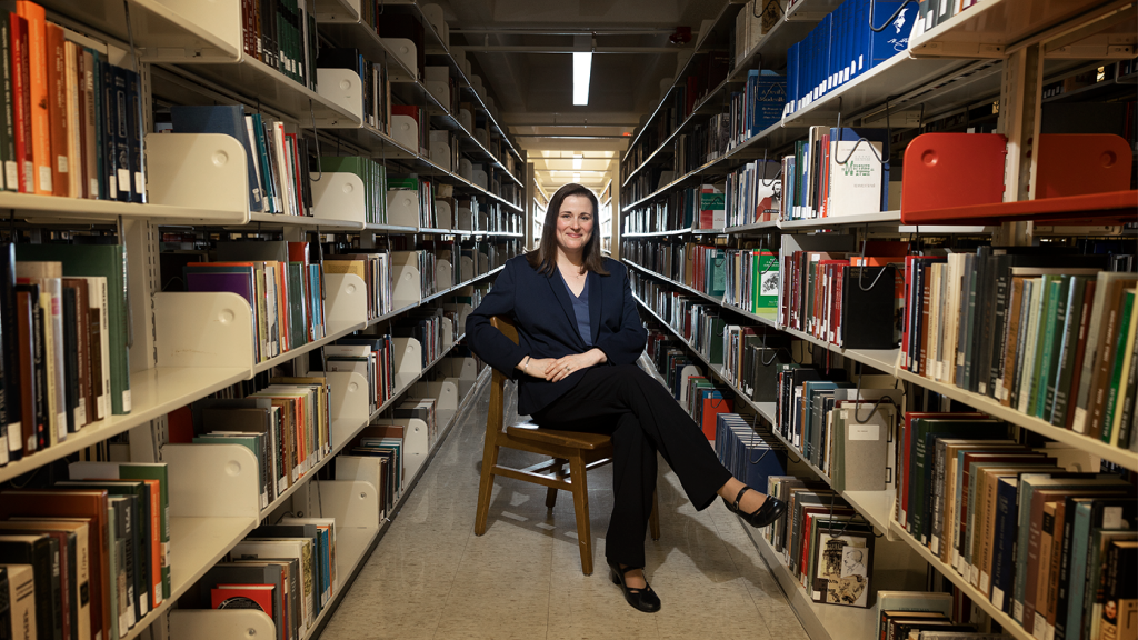 Amanda Henley pictured sitting in between the stacks of Davis Library
