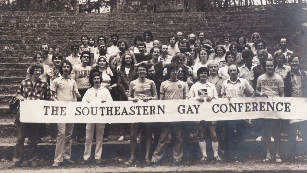 Black and white photo of a group of UNC students holding banner that says "The Southeastern Gay Conference"