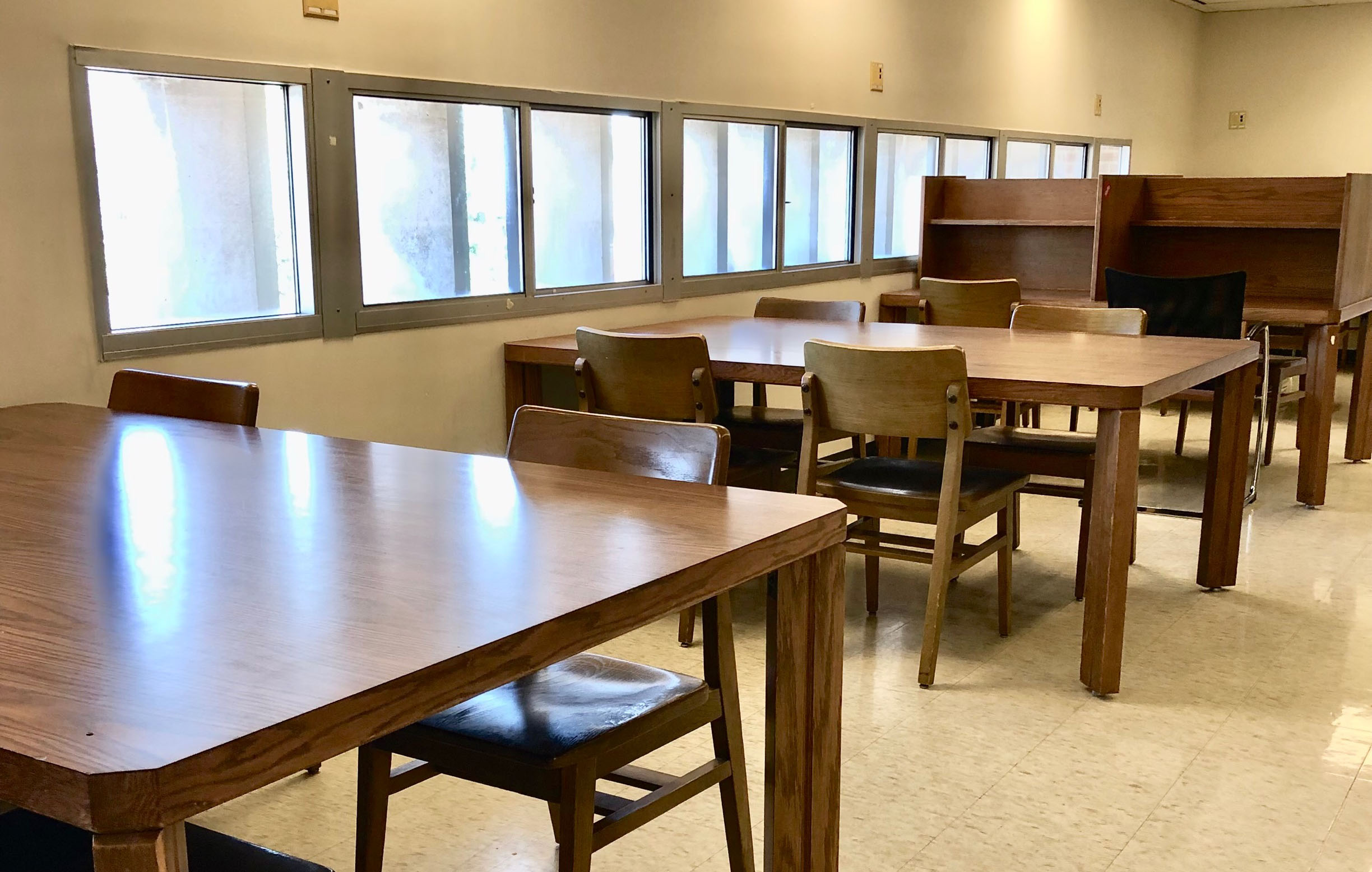 a row of study tables, with 4 chairs at each table.