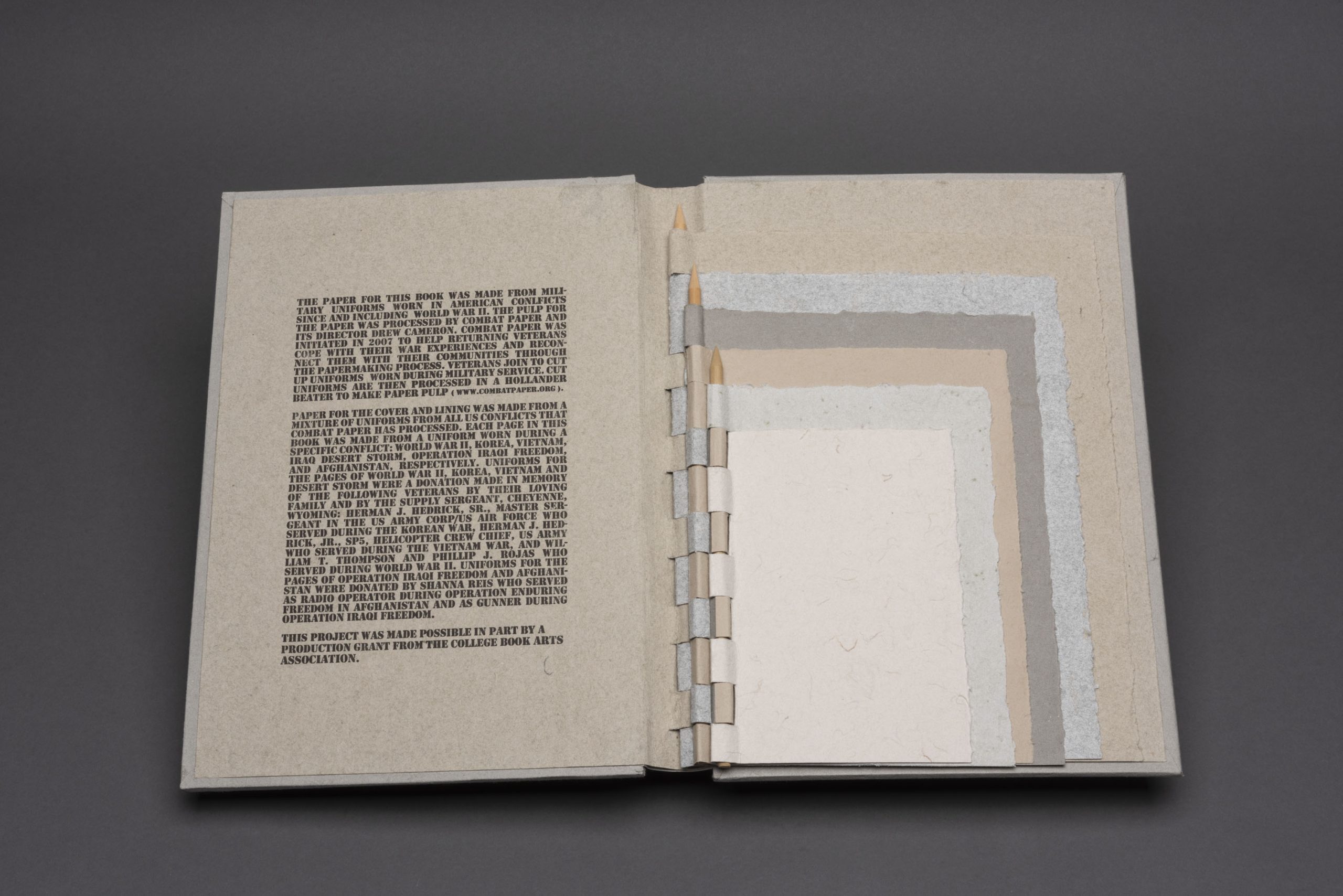 An artist's book with pages of handcrafted paper that were made by veterans from their military uniforms.