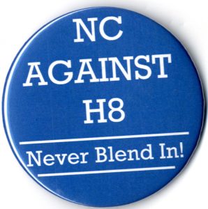 Button that reads "NC Against H8: Never Blend In!"