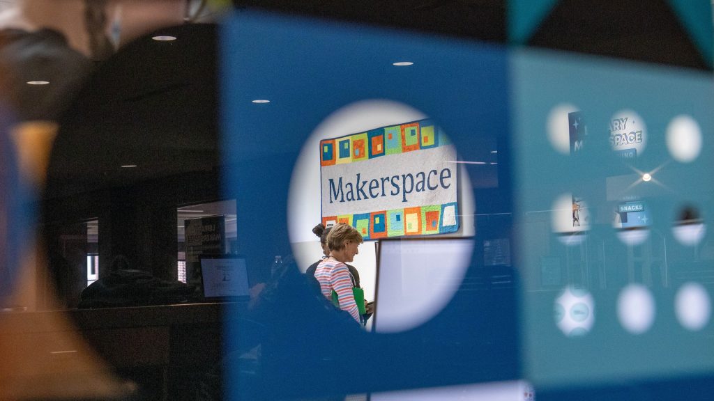 View of a quilted Makerspace sign through the window of the Library MakerSpace.